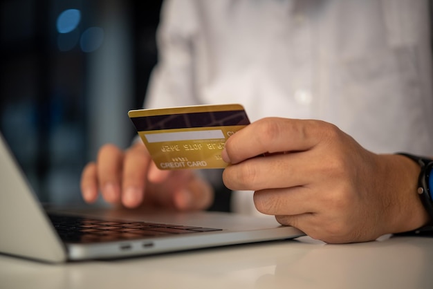 man hands holding credit card using internet payment laptop computer online shopping digital banking Business financial technology concept