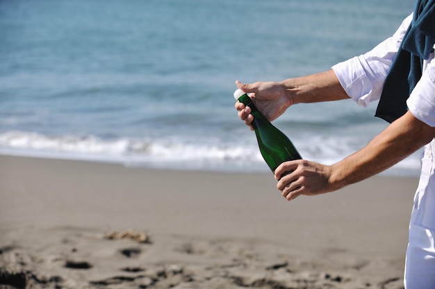 man hands open bottle of champagne alcohol and wine drink outdoor on party celebration event