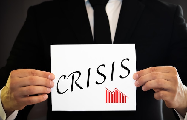 Photo man hands pressing the word crisis in black and white