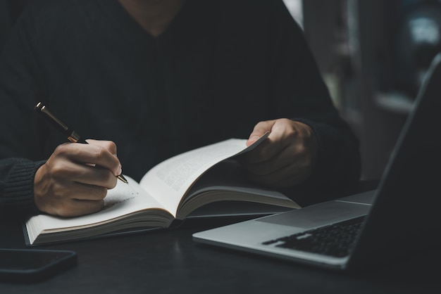 man hands with pen writing on notebook in the officelearning education and workwrites goals plans make to do and wish list on desk