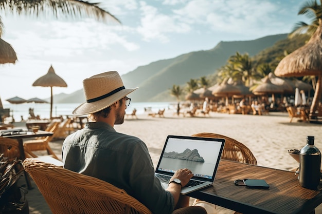 a man in a hat sitting at a table with a laptop