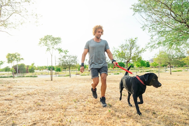 Man having fun and playing with his dog in the park.