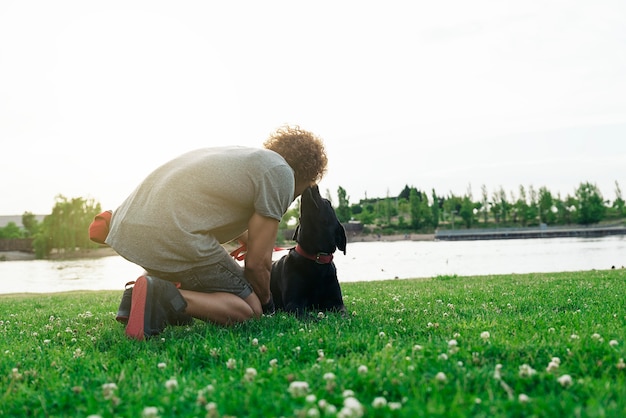 Man having fun and playing with his dog in the park.