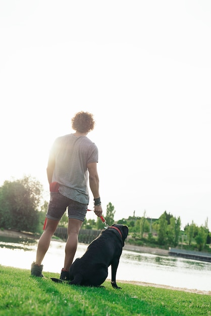 Man having fun and playing with his dog in the park.