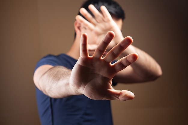 Man hides his face with his hands