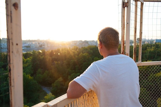 A man on a high tower looks at the sunset Portrait of a man at sunset