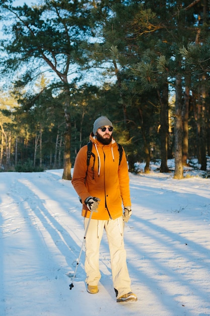 A man on a hike with a backpack in a snowy winter forest