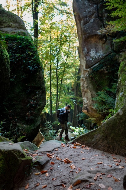 Man hiker with backpack in canyon with forest