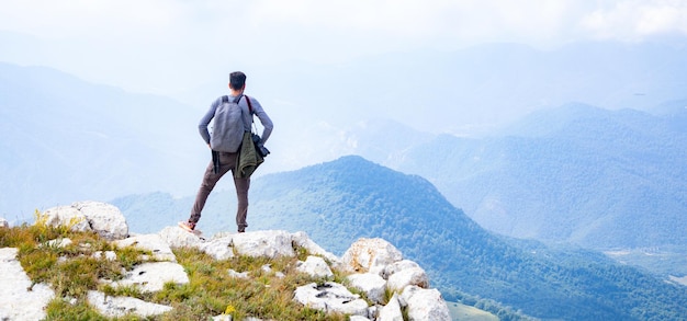 Man hiking in mountains with heavy travel backpack