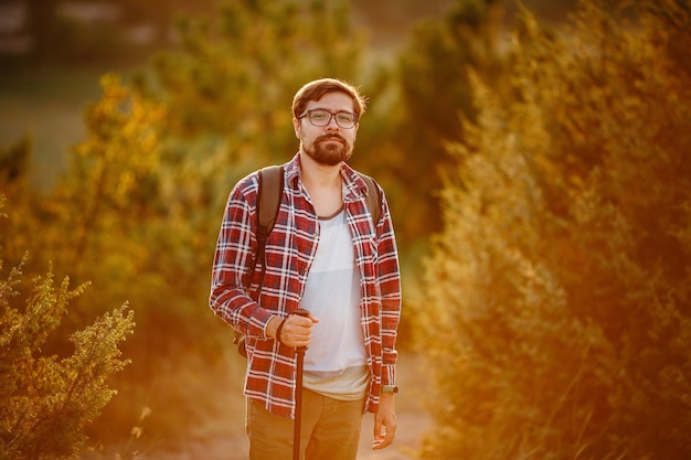 Man hiking at sunset mountains with backpack