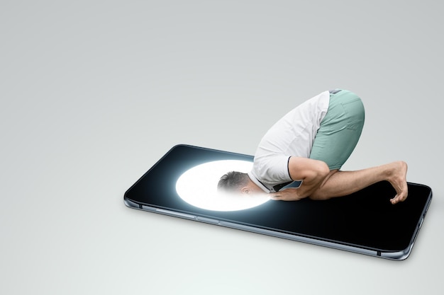 A man on his knees dives his head into the screen of a smartphone Dependence on social networks Internet addiction social disease Modern design magazine style