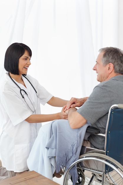 Man in his wheelchair with his nurse at home