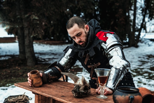 Man in a historical suit with a wooden glass at the table