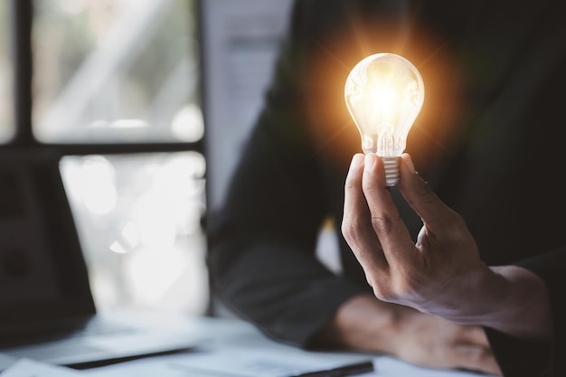 Man hold glowing light bulb Creative new idea Innovation brainstorming strategizing to make the business grow and be profitable Concept execution strategy planning and profit management