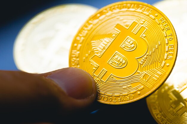 A man hold a gold coin of Bitcoin in macro photography