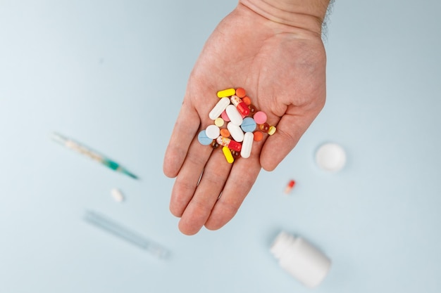 Man hold various pills in hand Medicines vitamins and antibiotics Selective focus First aid