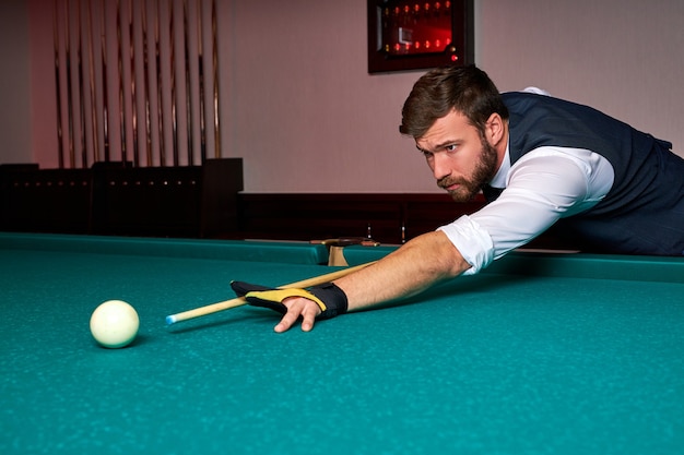 Man holding arm on billiard table, playing snooker game or preparing aiming to shoot pool balls. sport game snooker billiards