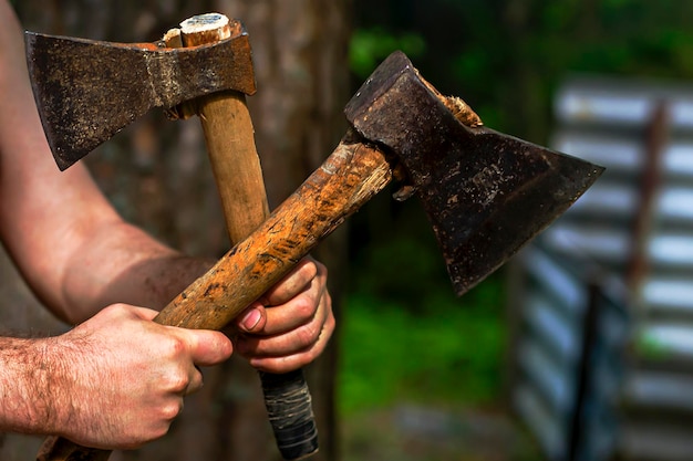 Man holding axes in nature