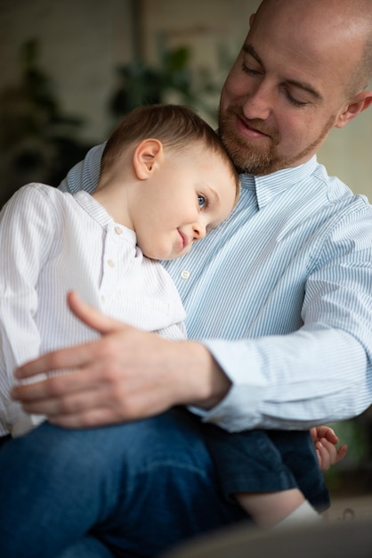 a man holding a baby with a shirt that says  dad  on it