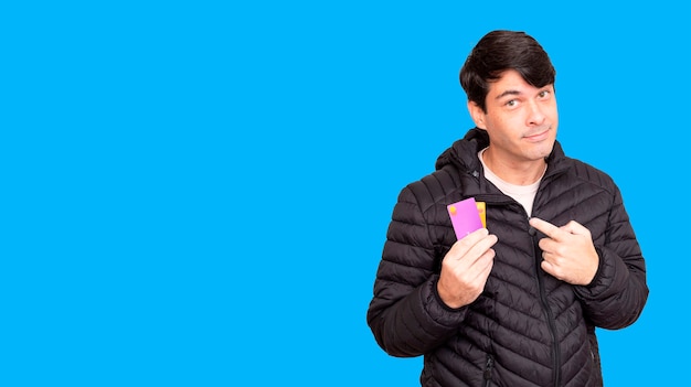 Man holding bank cards in one hand and with the other pointing.