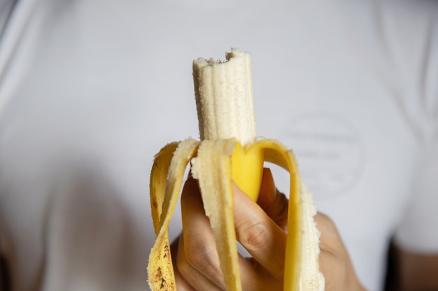 A man holding bitten banana