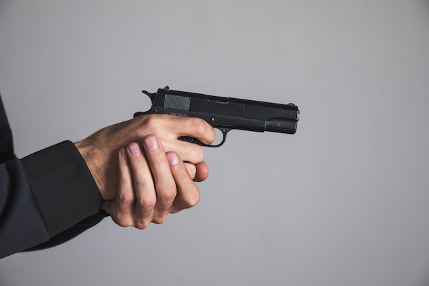 A man holding a black pistol in his hand threatening