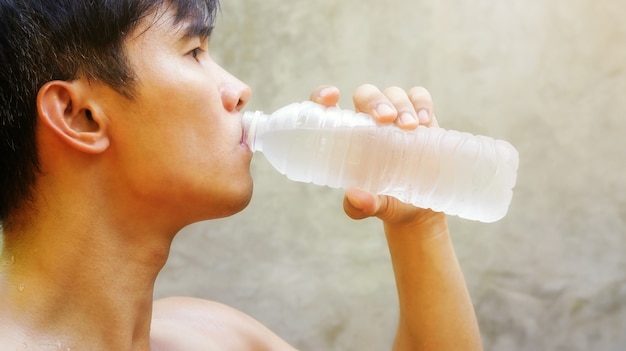 Man holding a bottle of water and drink.