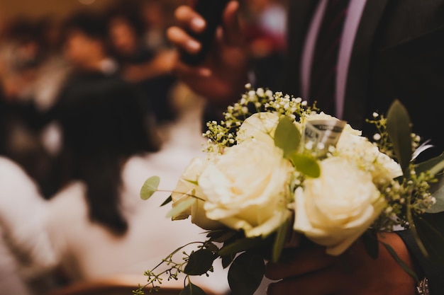 A man holding a bouquet of white roses