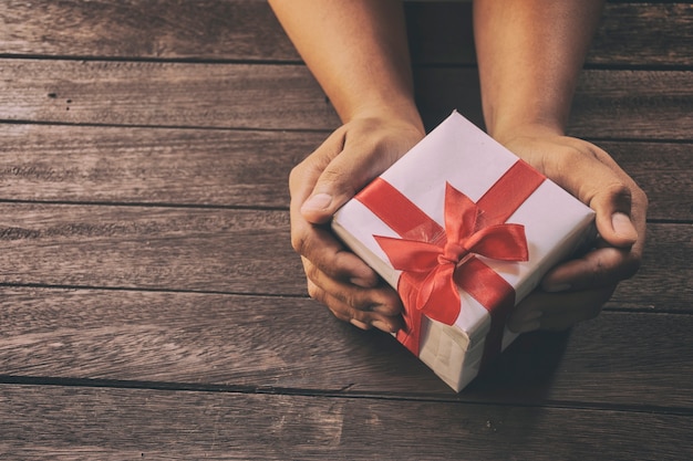 Man holding Christmas presents laid on a wooden table background