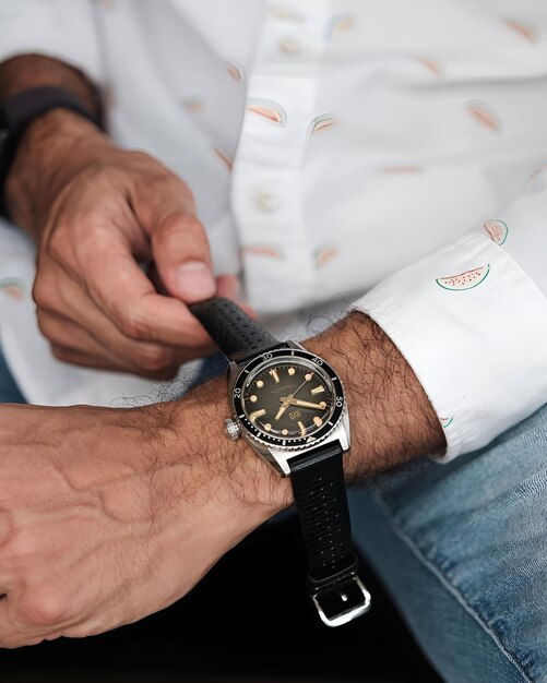 a man holding a classic silver amp black watch with a black band or strap