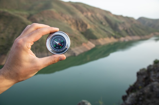 Man holding a compass on the surface of nature