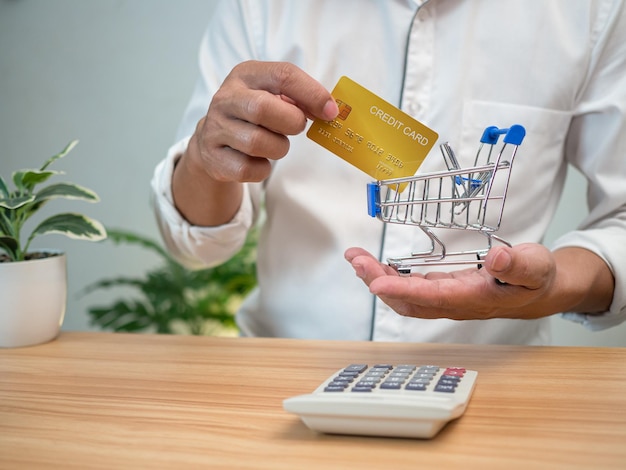 Man holding a credit card and pressing a calculator Shopping concept Cashless payment concept