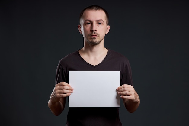 Man holding an empty paper sheet in his hands