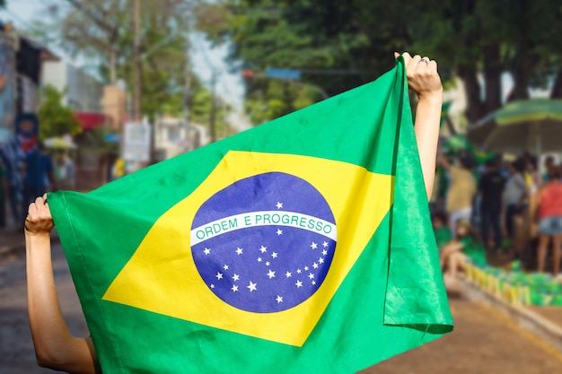 Man holding flag at street demonstration in Brazil.