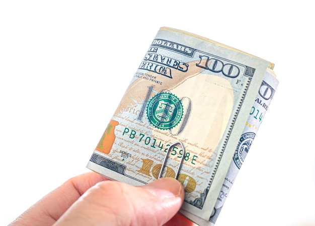 a man holding folded US dollar bills on a white background