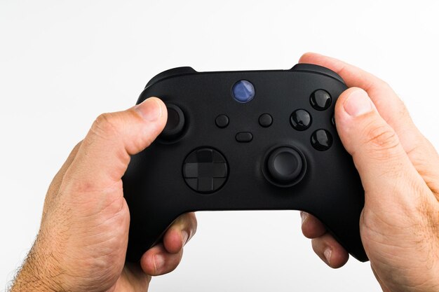 Man holding a Next generation black game controller isolated on white background.