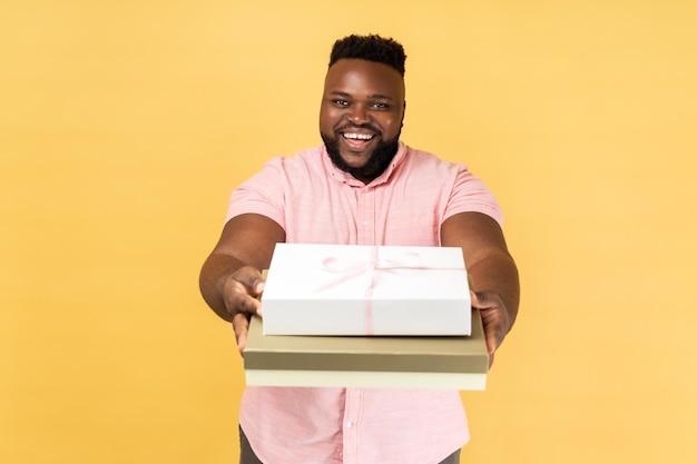 Man holding giving present boxes congratulating looking at camera with toothy smile