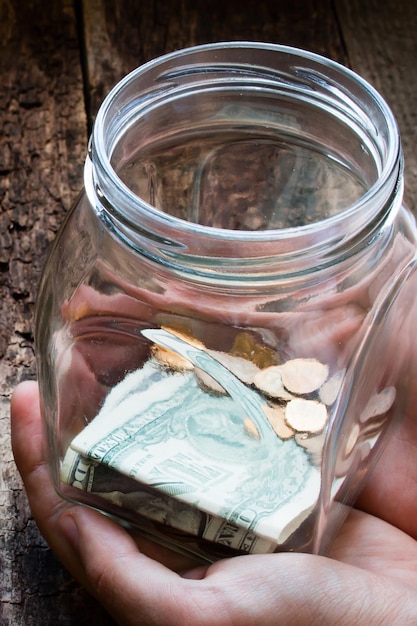 Man holding a glass jar for donations