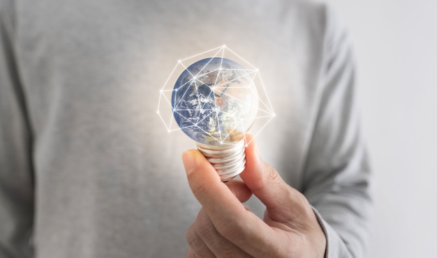 a man holding glowing earth light bulb