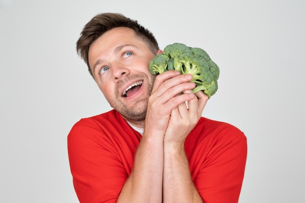 Man holding green fresh broccoli isolated on white background