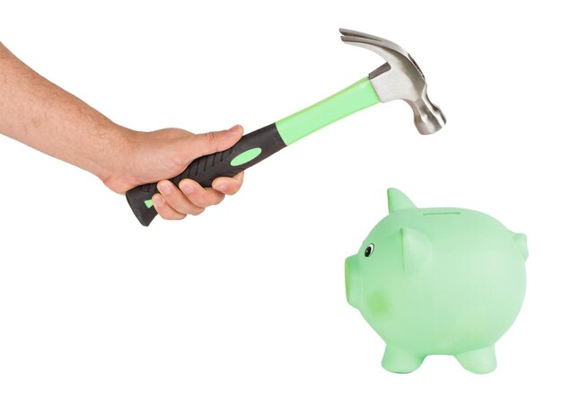 Man holding a hammer and breaking a piggy bank