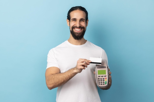 Man holding in hand pos payment terminal going to make payment with card cashless purchases