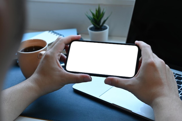 Man holding horizontal smart phone with white screen