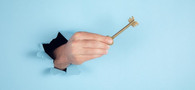 Man holding key on blue background