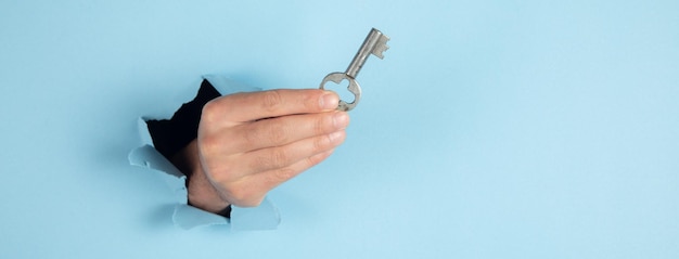 Man holding key on blue background