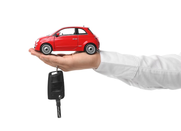 Man holding key and miniature automobile model on white background closeup Car buying