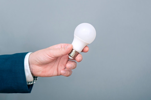 A man holding led light bulb in hand. Concept picture about economy, electricity and saving money