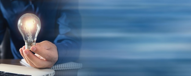 Man holding light bulb and working at office