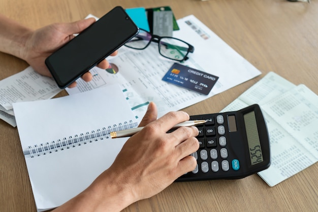 Man holding mobile phone and using calcutor, account and saving concept