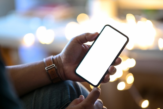 Man holding mobile smart phone at street night with blurred background	